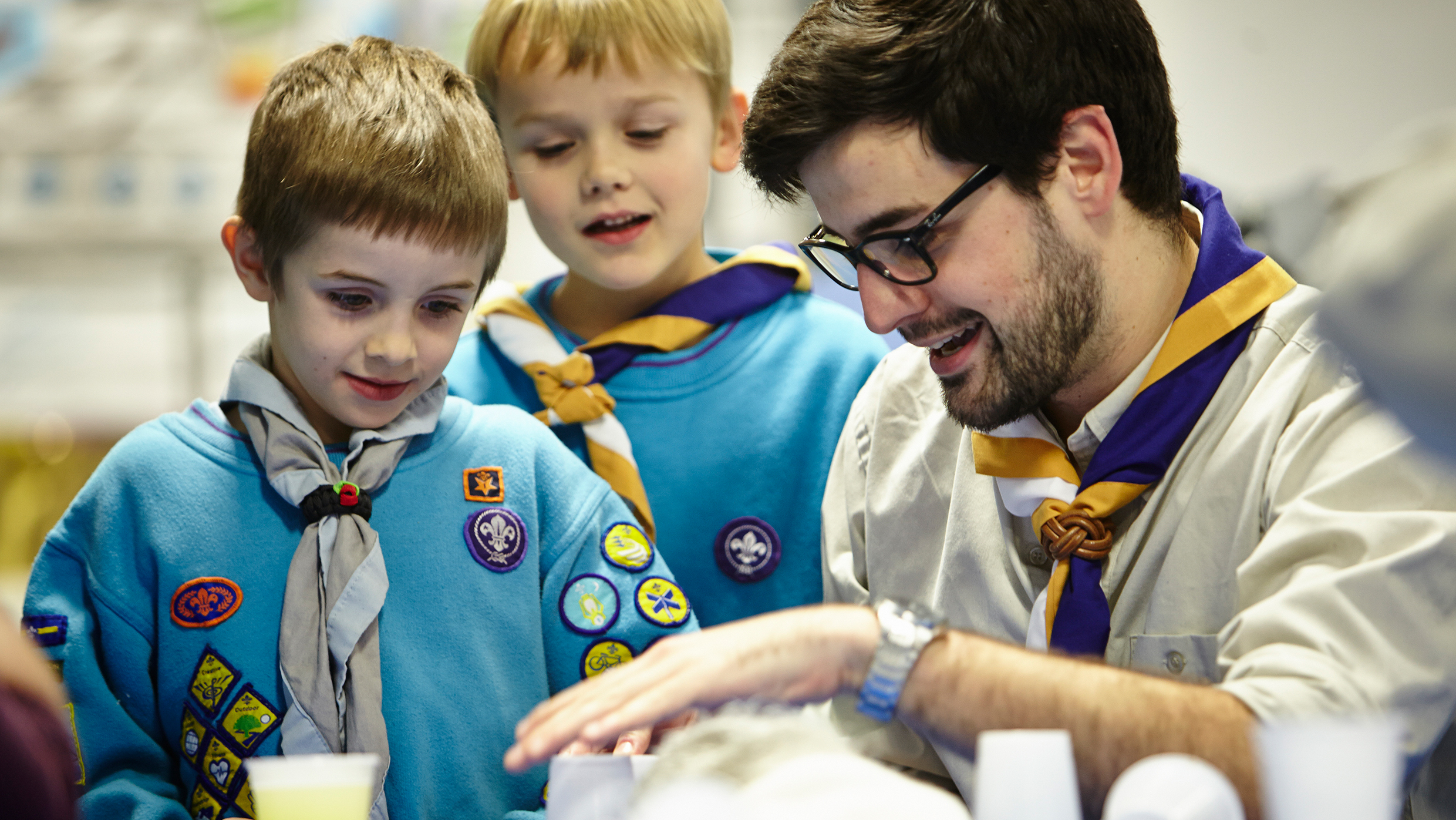 Beavers leader helping children at a desk
